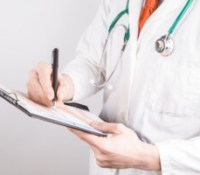 Un médecin écrivant sur un document // Source : George Hodan, CC0 Public Domain