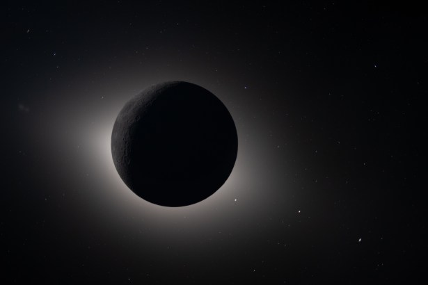 art002e009301 (April 6, 2026) – Captured by the Artemis II crew during their lunar flyby on April 6, 2026, this image shows the Moon fully eclipsing the Sun. From the crew’s perspective, the Moon appears large enough to completely block the Sun, creating nearly 54 minutes of totality and extending the view far beyond what is possible from Earth. The corona forms a glowing halo around the dark lunar disk, revealing details of the Sun’s outer atmosphere typically hidden by its brightness. Also visible are stars, typically too faint to see when imaging the Moon, but with the Moon in darkness stars are readily imaged. This unique vantage point provides both a striking visual and a valuable opportunity for astronauts to document and describe the corona during humanity’s return to deep space. The faint glow of the nearside of the Moon is visible in this image, having been illuminated by light reflected off the Earth.