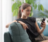 Adolescente regardant son smartphone avec les réseaux sociaux // Source : Adobe Stock